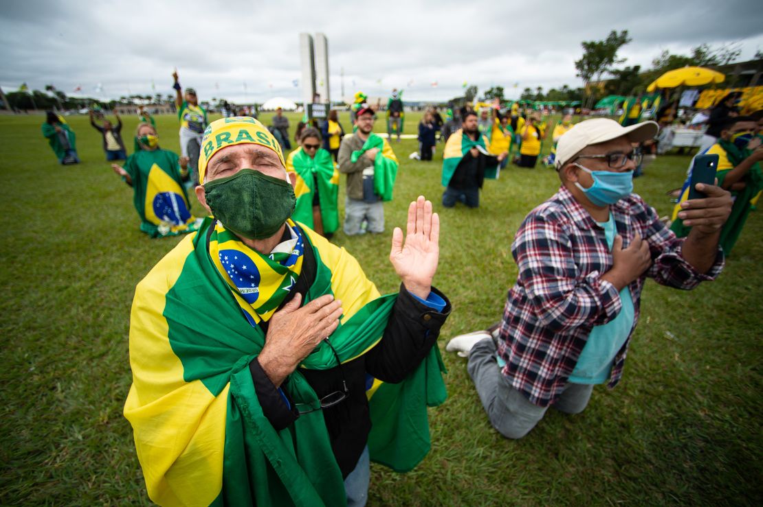 Supporters of Brazilian President Jair Bolsonaro pray during a motorcade and protest against the National Congress and the Supreme Court over lockdown measures amidst on the coronavirus (COVID-19) pandemic in front the National Congress on May 09, 2020 in Brasilia.