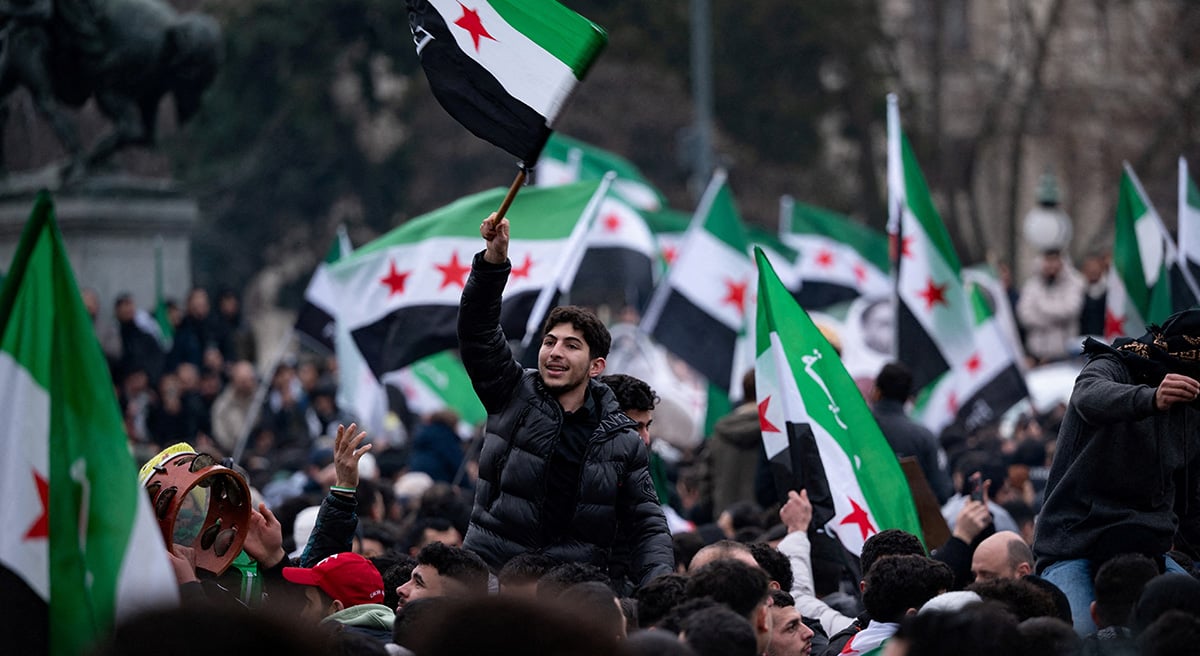 People wave flags as they gather in front of the parliament, after Syrian rebels announced that they have ousted President Bashar al-Assad, in Vienna, Austria, December 8, 2024. — Reuters