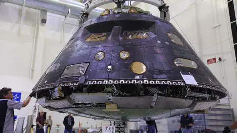 Nasa/Leif Heimbold The Orion crew module is pictured - it is the shape of an upturned bowl and has a metallic-looking surface