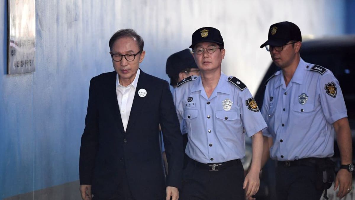 FILE: Former South Korean president Lee Myung-bak (L) arrives at a court to attend his trial in Seoul on September 6, 2018. Prosecutors demanded 20 years in prison for former South Korean president Lee Myung-bak for corruption, the last of the country's four living ex-leaders to be embroiled in a criminal inquiry. 