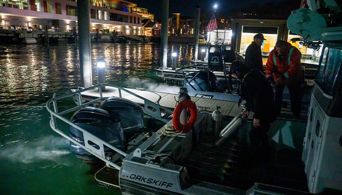 An emergency response team with Washington, DC Fire and EMS and DC Police load diving equipment on a boat to continue working the scene of airplane wreckage in the Potomac River near Ronald Reagan Washington Airport on January 30, 2025 in Arlington, Virginia. — AFP