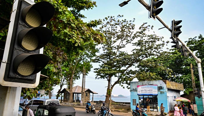 Commuters ride past inoperative traffic lights following a nationwide power outage in Galle on February 9, 2025. — AFP