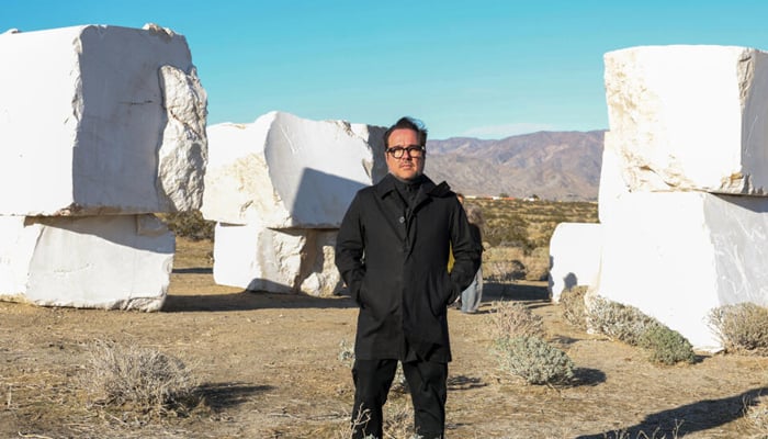 Mexican artist Jose Davila poses in front of his piece The Act of Being Together, made of stacked 16-ton marble boulders ahead of the Desert X exhibit in Californias Coachella Valley. — AFP