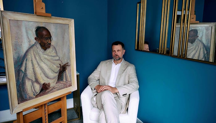 Caspar Leighton, great-nephew of British-American artist Clare Leighton, poses with a painting by his great-aunt of Indian independence leader Mahatma Gandhi at Bonhams auction house in London on June 9, 2025. — AFP