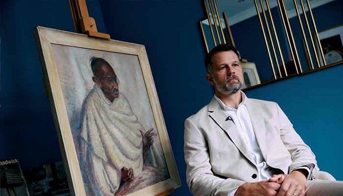 Caspar Leighton, great-nephew of British-American artist Clare Leighton, poses with a painting by his great-aunt of Indian independence leader Mahatma Gandhi at Bonhams auction house in London on June 9, 2025. — AFP