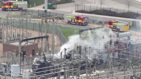PA Media Picture of smoke billowing out a the North Hyde substation in March. Two fire engines are on the adjacent road. 