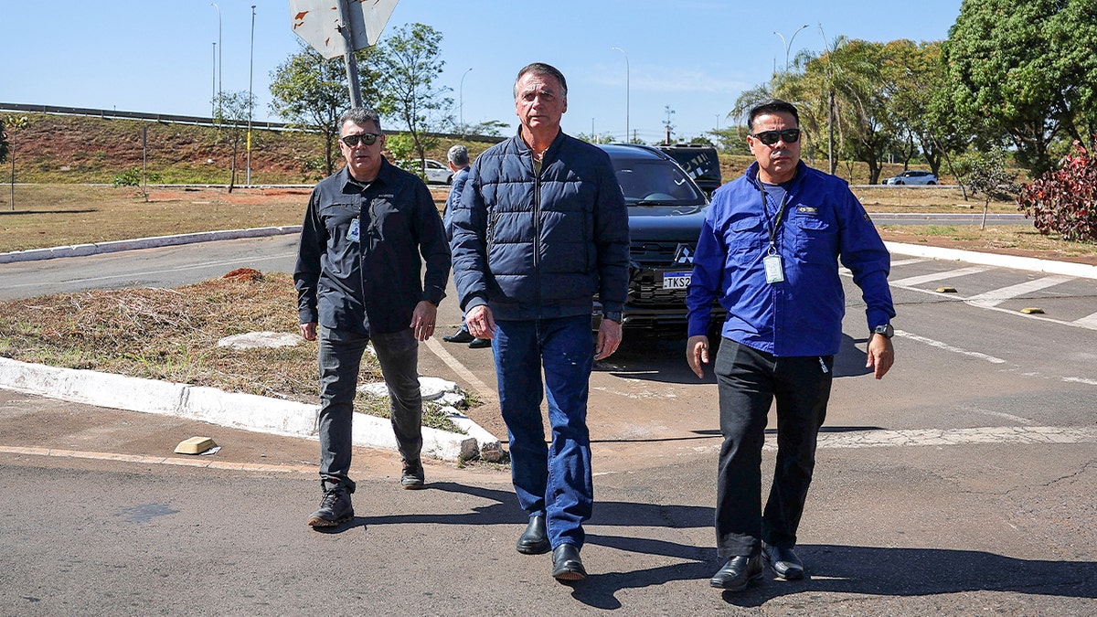Former Brazilian President Jair Bolsonaro walking toward the Secretariat of Penitentiary Administration headquarters