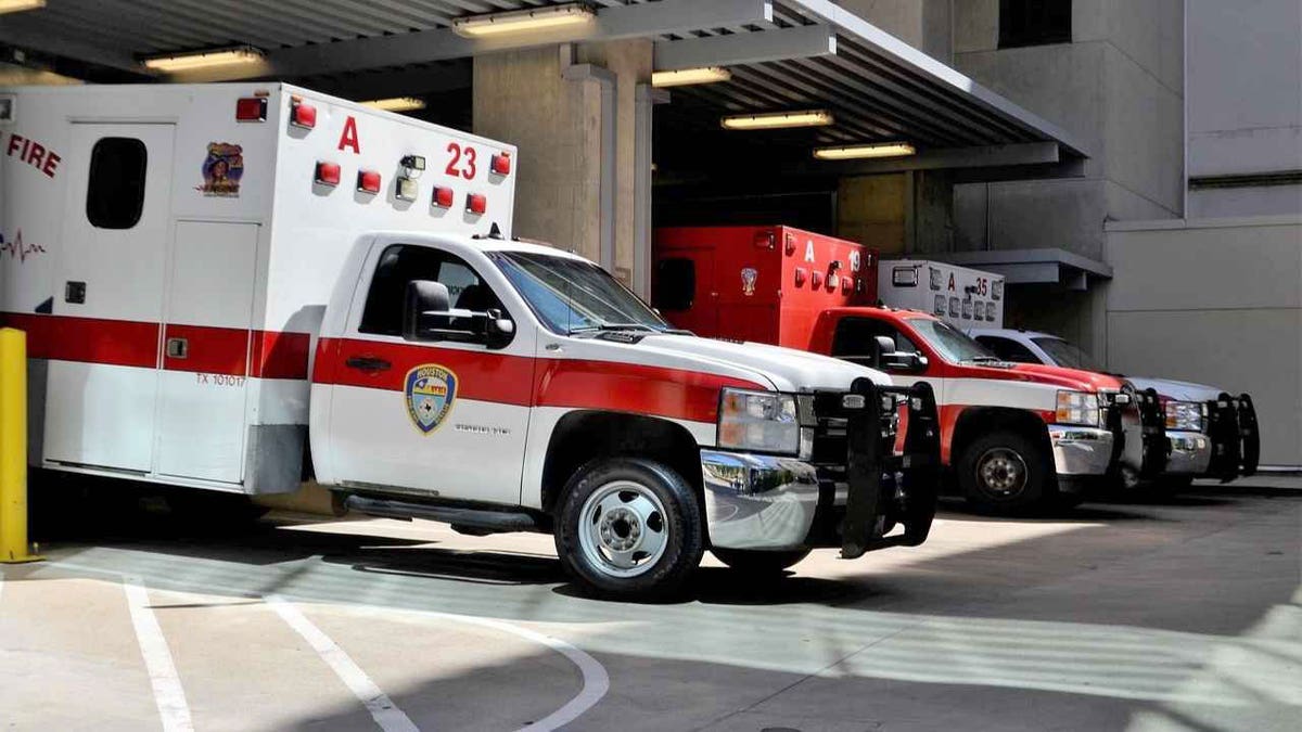 A row of ambulances parked at a hospital emergency bay, ready for dispatch.