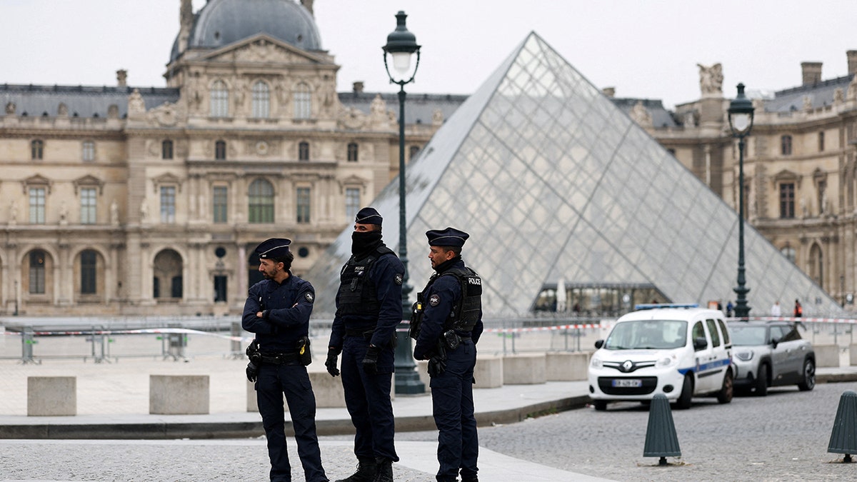 police officers in uniform standing outside the Louvre